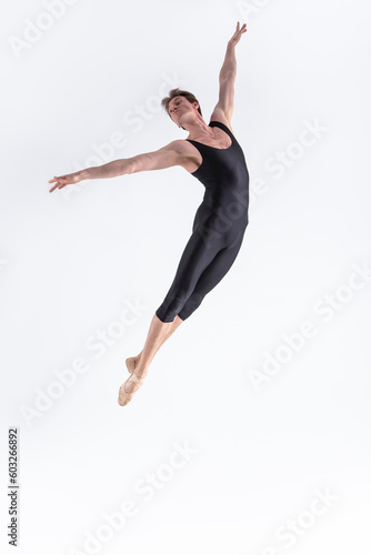 Ballet Dancer Young Man in Black Dance Suit Posing in Flying Ballanced Dance Pose Studio.
