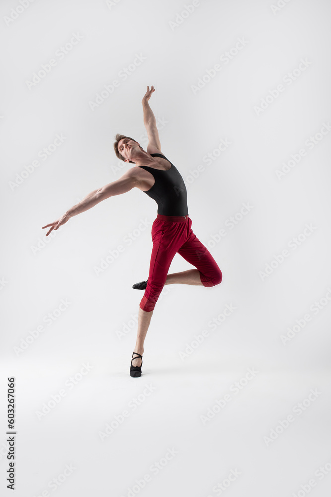 Ballet Sport Ideas. Contemporary Ballet of Flexible Athletic Man Posing in Red Tights in Dance Pose With Hands Lifted in Studio