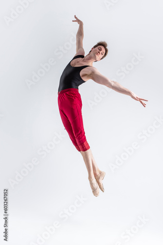 Malea Dancer. Contemporary Art Ballet With Young Flexible Athletic Man Posing in Flying Dance Pose in Studio on White