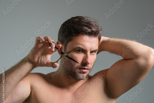 Men hairstyle, haircut. Middle aged man with scissors cut hair. Men haircare, beauty barber concept. Bearded guy, with scissors. Cut hair with scissors. Mans hair styling and cut hair with scissors.