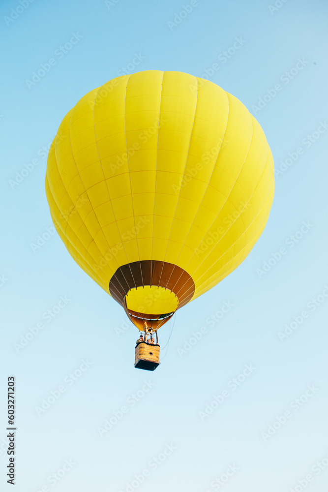 Fototapeta premium view of air balloon with basket flies on sunset