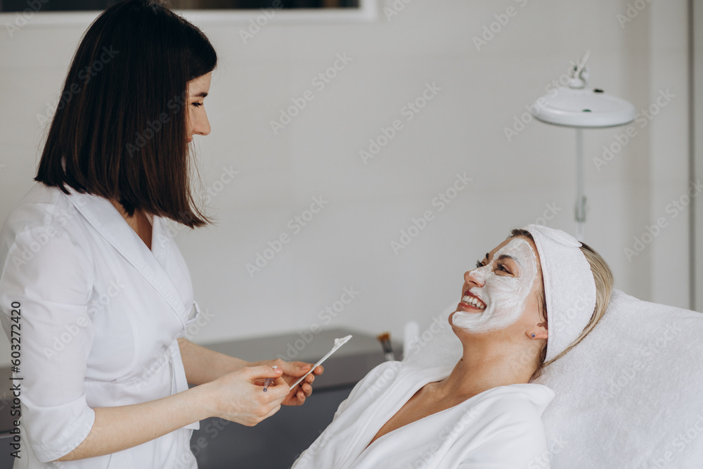 Woman in mask on face in spa beauty salon. Woman in mask on face in spa beauty salon.
