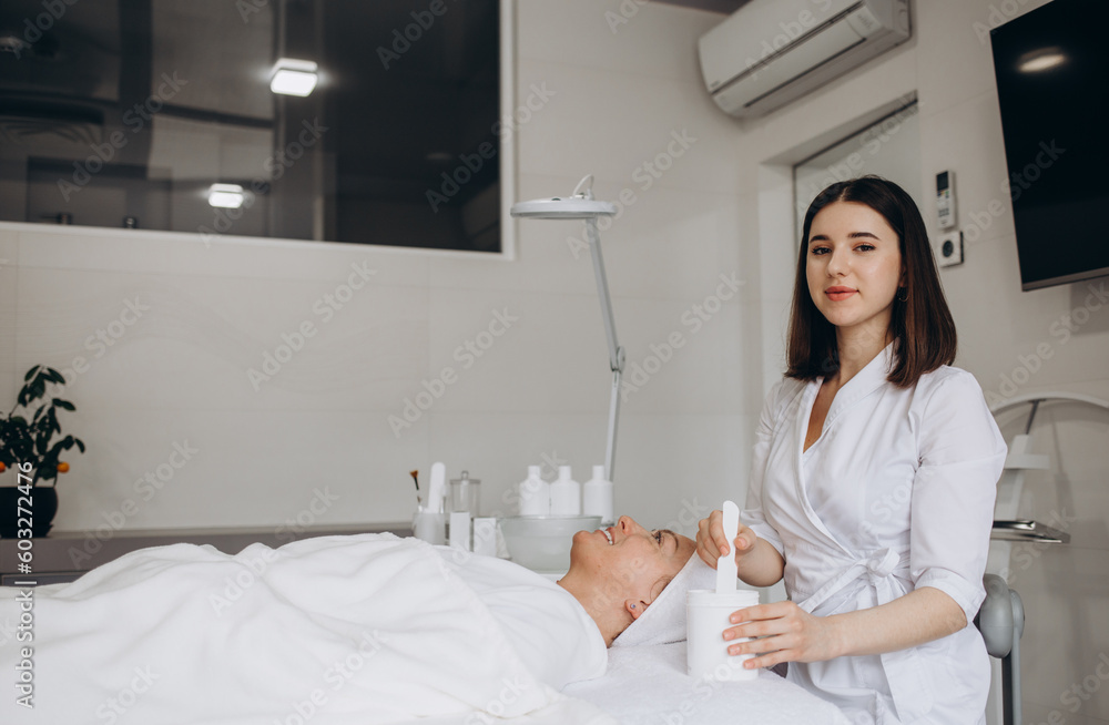 Happy calm relaxed young woman or teenage girl lying on soft towel in beauty parlor or spa salon Happy calm relaxed young woman or teenage girl lying on soft towel in beauty parlor or spa salon