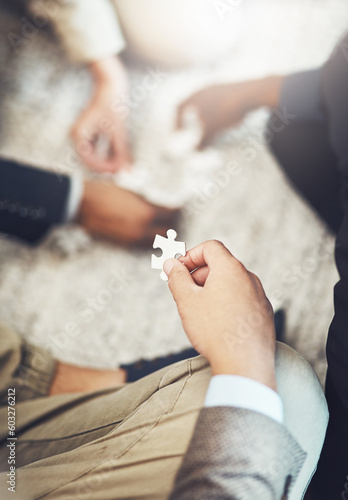 Businessman, hands and puzzle piece in team building, meeting or problem solving together at office. Hand of man person in teamwork, jigsaw activity or collaboration for project together at workplace