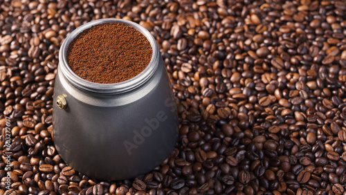 Kawiarka postawiona na palonych ziarnach kawy