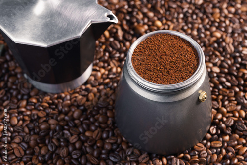 Kawiarka postawiona na palonych ziarnach kawy