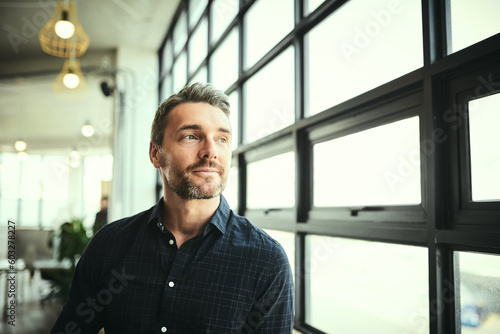 Thinking, ideas and face of man at office window, creative startup and business project for entrepreneur at design agency. Boss with creativity, job idea and focus, businessman with plan in workplace