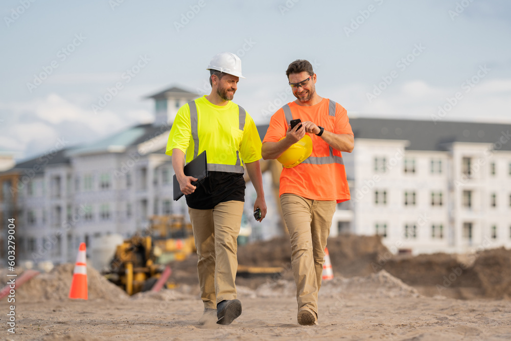 Two engineers. Architect at a construction site. Handyman builders in hardhat. Building concept. Builder foreman. Two hispanic men, construction workers in helmet at construction site.