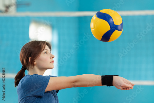 Female player learning fundamental skills in volleyball. Girl practicing digging to receive and save the ball from hard-given attack of the opponents