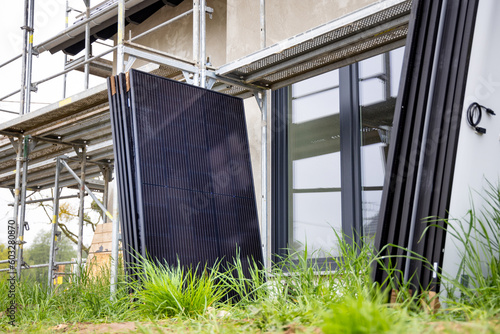 Solar Panels Awaiting Installation next to Scaffolding on a Construction Site © photoschmidt