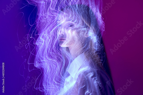 Neon electric smoke. Young girl looking at camera over fluorescent lights against gradient blue purple background. Concept of art, modern style, cyberpunk, futurism and creativity
