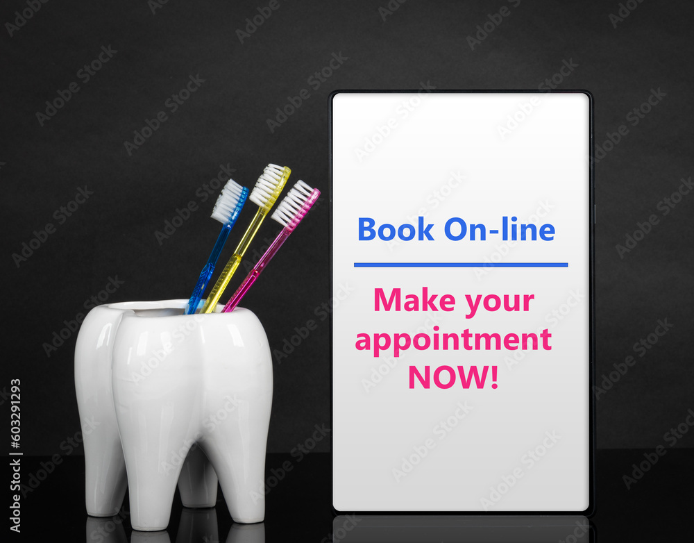 Dentist appointment date or any other dental message on tablet, ceramic tooth with three bright colors toothbrushes mockup. Black background.