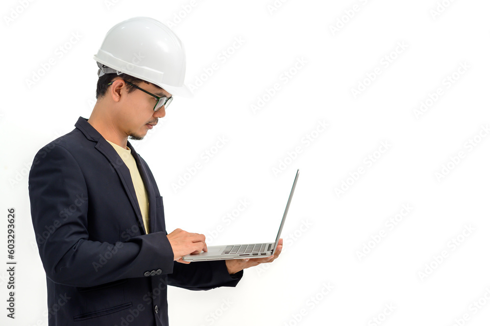 Portrait of Asian male architect or engineer wearing white hard hat holding laptop isolated on white background Copy space over a white studio background. Portrait of Asian male architect or engineer wearing white hard hat holding laptop isolated on white background Copy space over a white studio background.