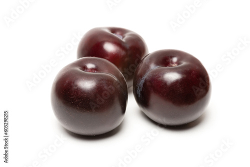 three fresh ripe plum on a white background