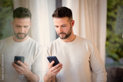 Confident man wearing casual clothes and having call while standing indoor