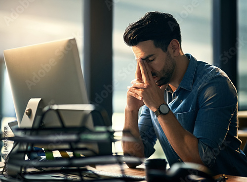 Stress, headache and tired with a business man in his office, sitting eyes closed at his desk for a deadline. Night, burnout and exhausted with a young male employee struggling with pain at work