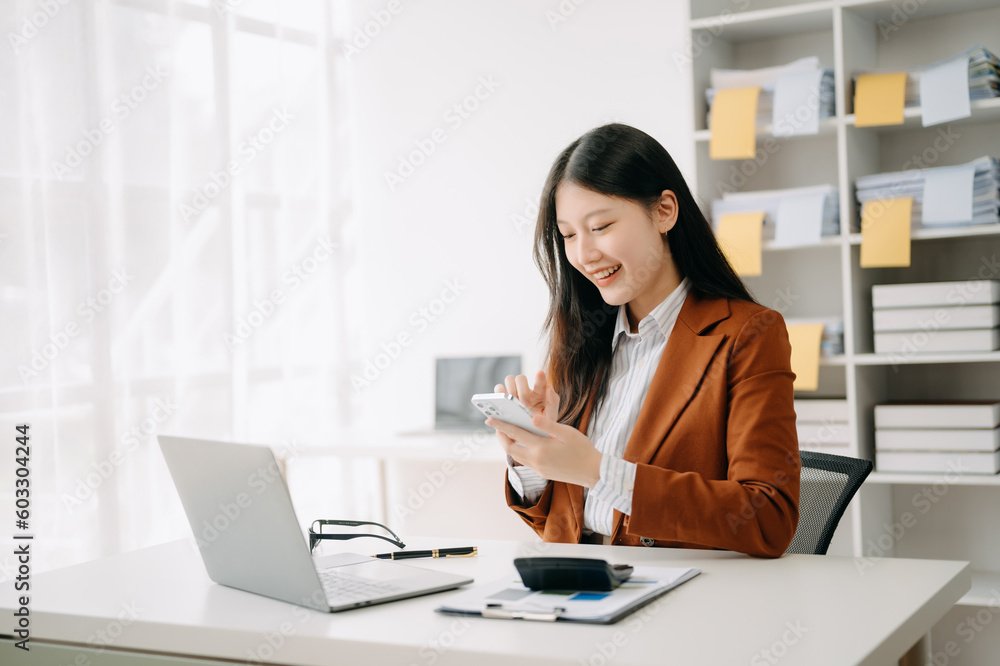 Asian businesswoman working in the office with working notepad, tablet and laptop documents in office