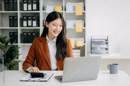 Asian businesswoman working in the office with working notepad, tablet and laptop documents in office