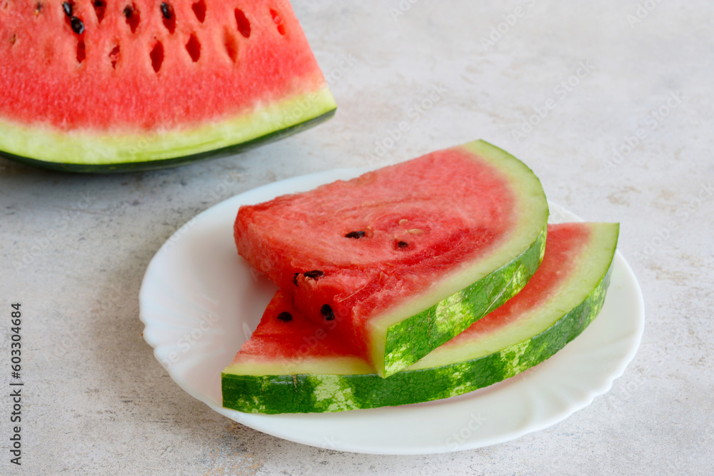 A plate of watermelon slices on a table isolated, close up A plate of watermelon slices on a table isolated, close up