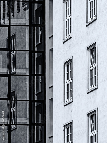 Schwarz-weiße Aufnahme des Kontrastes alter und moderner Architektur mit Spiegelung