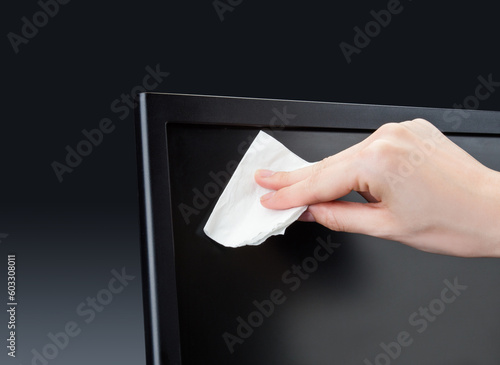 Holding an alcohol containing disinfectant wipes in hand while wiping items