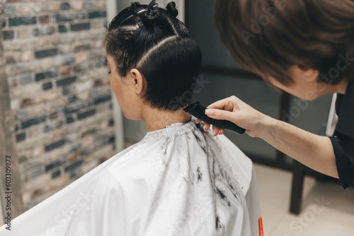 the hairdresser straightens the girl's hair after a short haircut