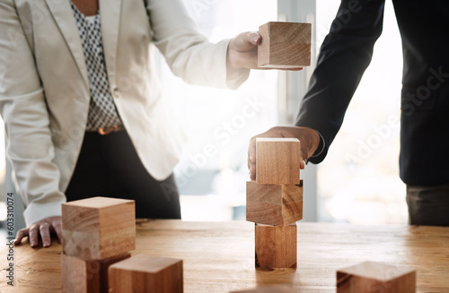 Hands, wood building blocks and business people in partnership with strategy, problem solving and support. Teamwork, wooden toys and together with puzzle, synergy and mindset for solution in office