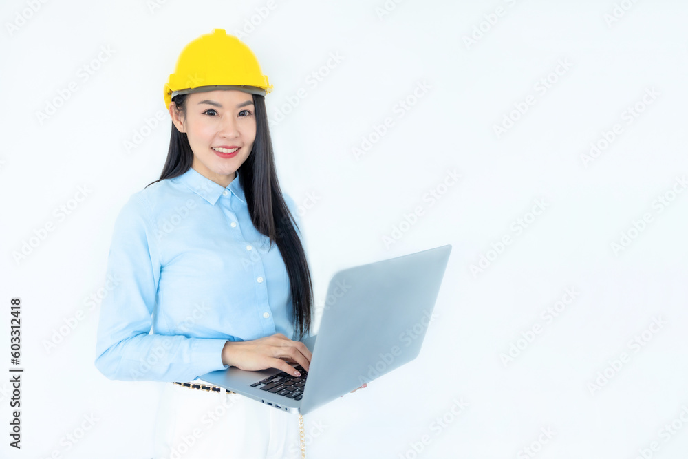Asian woman architect or construction engineer wear yellow hardhat on white background.Young asian architect woman smiling happy.Asian woman architect looking and using at laptop. Industry concept. Asian woman architect or construction engineer wear yellow hardhat on white background.Young asian architect woman smiling happy.Asian woman architect looking and using at laptop. Industry concept.