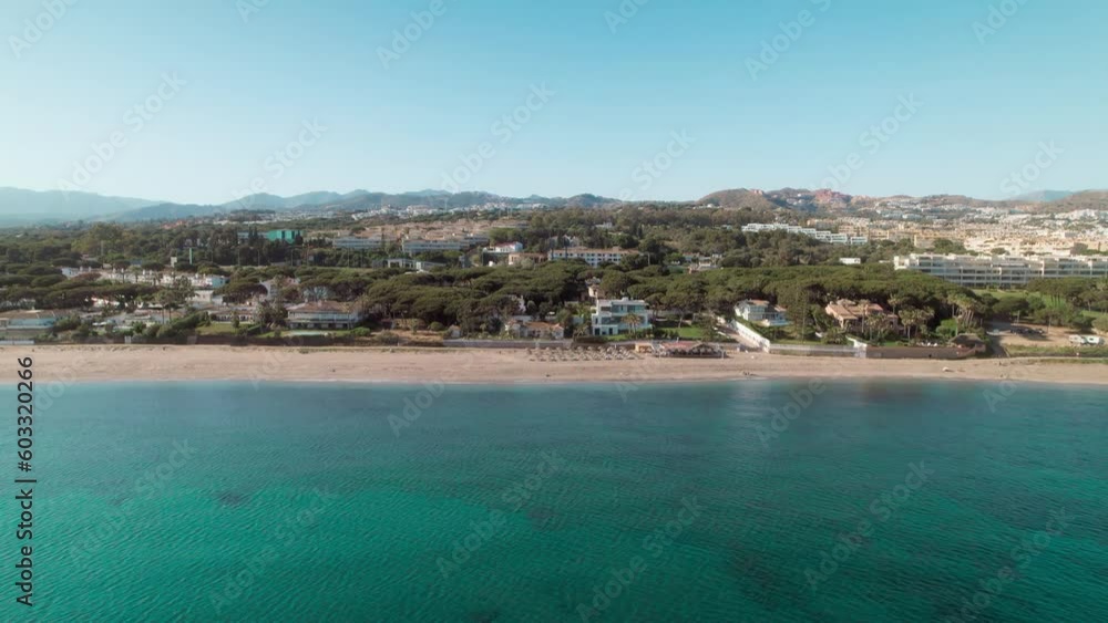 Cabopino Beach, Aerial moving forward from the sea into the beach, getting closer to the coastline buildings. Andalusia, Spain Cabopino Beach, Aerial moving forward from the sea into the beach, getting closer to the coastline buildings. Andalusia, Spain