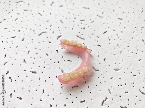Flexible teeth in one hand with a medical clinic background