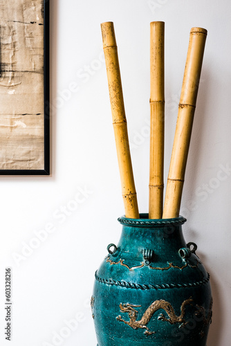 Bamboo Poles In A Green Chinese Urn Decorated With Dragons photo