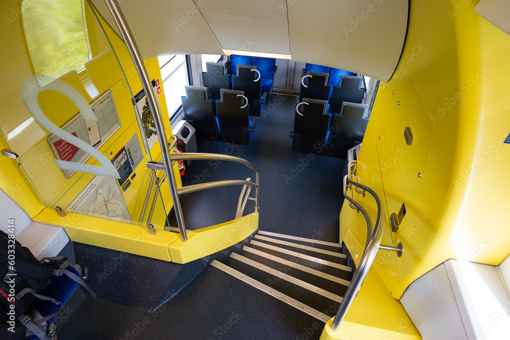 Empty seats and stairs on a Double Decker passenger train in Europe. Wide-angle view, day time, no people