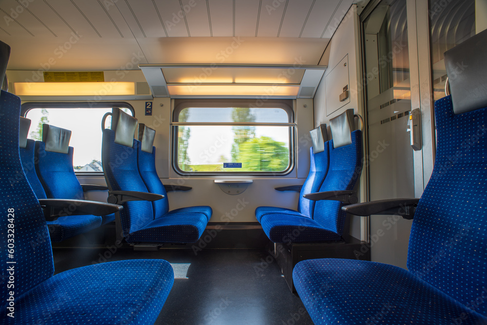 Passenger train with empty seats. Wide-angle long exposure, blurry green background out the window of an empty train in Switzerland, Europe, no people