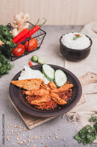 Otak otak sambal gami or spicy fish cake is Traditional food from Indonesia. served on plate with a bowl of rice and vegetables. Isolated gray background and photo
