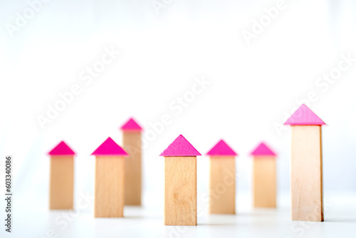Wooden blocks forming house and building shapes on white background, house building modeling concept.