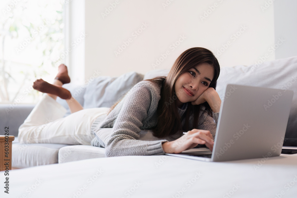 Attractive Asian woman resting comfortable living room and using laptop computer, Relax, Sofa, Lifestyle Attractive Asian woman resting comfortable living room and using laptop computer, Relax, Sofa, Lifestyle