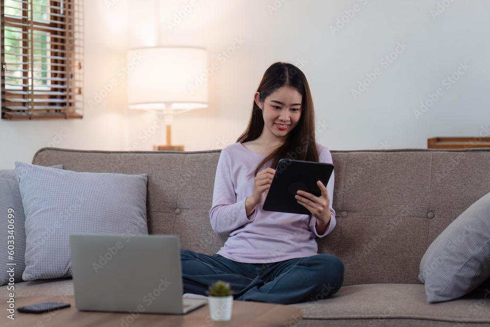 Attractive Asian woman resting comfortable living room and using digital tablet, Relax, Sofa, Lifestyle Attractive Asian woman resting comfortable living room and using digital tablet, Relax, Sofa, Lifestyle