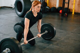 Ready to lift the barbell. Beautiful strong woman is in the gym