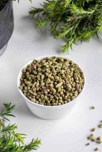Bundle of fresh green aromatic thyme herbs with dried thyme seeds in a bowl. 