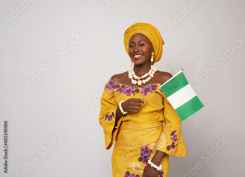 Portrait of happy Nigerian woman waving the national flag 