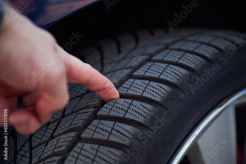 Close up view of man's hand that touching the automobile tire