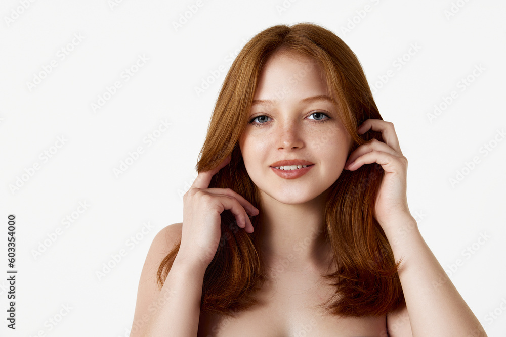 Portrait of young, pretty, redhead girl with well-kept, perfect skin and hair, looking at camera against white studio background. Natural beauty, hair care, cosmetology, cosmetics, skin care concept Portrait of young, pretty, redhead girl with well-kept, perfect skin and hair, looking at camera against white studio background. Natural beauty, hair care, cosmetology, cosmetics, skin care concept