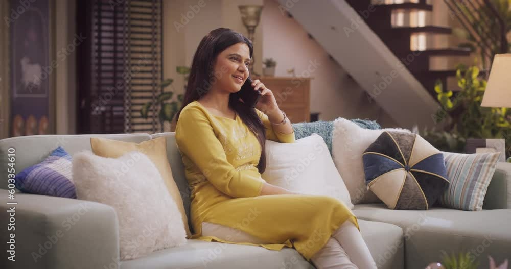 Gorgeous Indian Woman Engaged in a Lively Phone Call at Home: Discussing Work Matters with Colleagues or Clients. Sharing Stories and Laughs with Girlfriends, or Catching Up with Family. Medium Shot Gorgeous Indian Woman Engaged in a Lively Phone Call at Home: Discussing Work Matters with Colleagues or Clients. Sharing Stories and Laughs with Girlfriends, or Catching Up with Family. Medium Shot