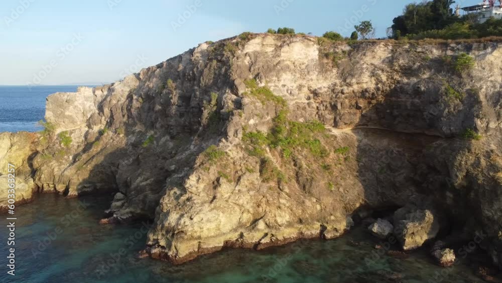 Aerial view of stone cliff at sunset. Stone cape covered with trees and seascape. Aerial view of stone cliff at sunset. Stone cape covered with trees and seascape.