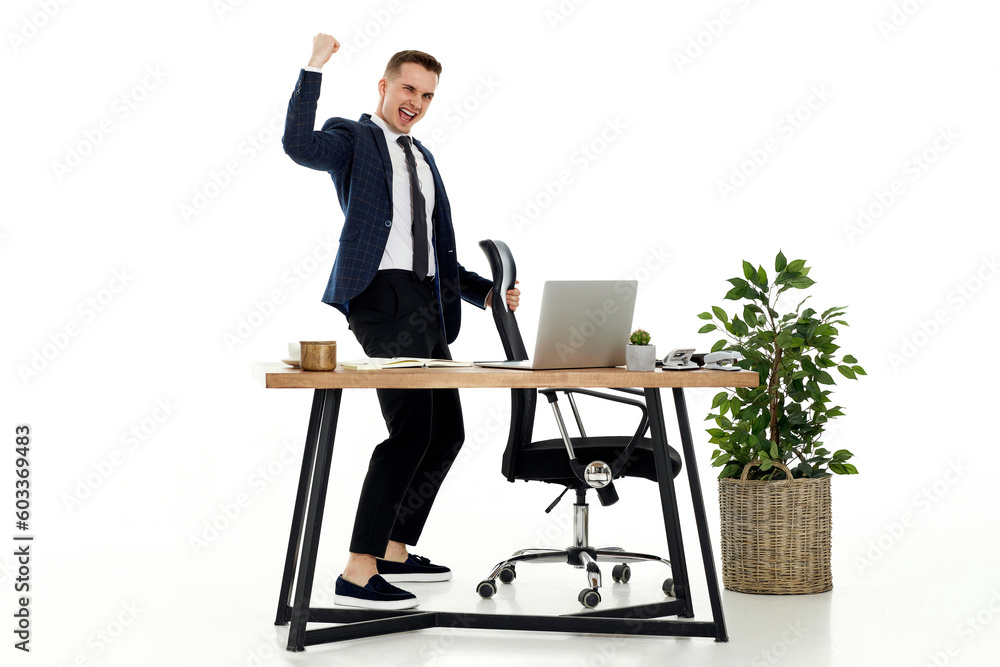 young businessman gesturing emotionally and celebrating victory
