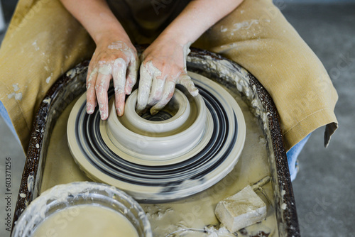 close up view of professional potter working on pottery wheel at workshop. High quality photo