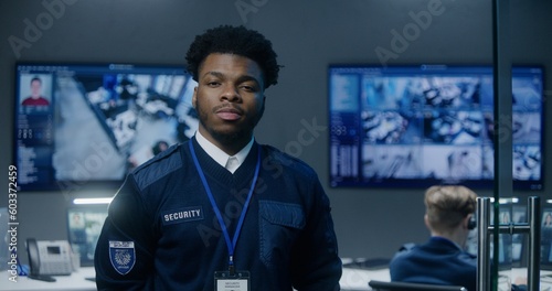 фотографія Portrait of African American security officer in police monitoring center looking at camera