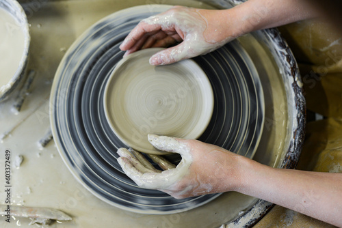 close up view of professional potter working on pottery wheel at workshop. High quality photo