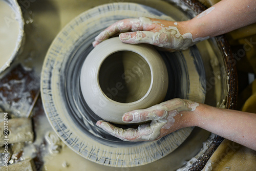 close up view of professional potter working on pottery wheel at workshop. High quality photo