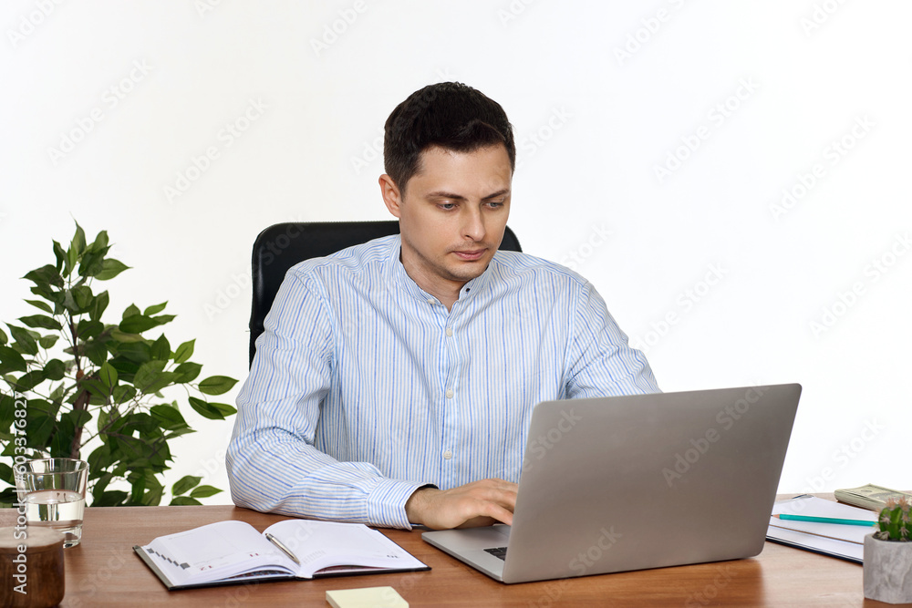 young man using laptop computer for online work at table young man using laptop computer for online work at table